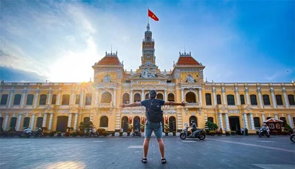 Man posing in front of Ho Chi Minh City Hall